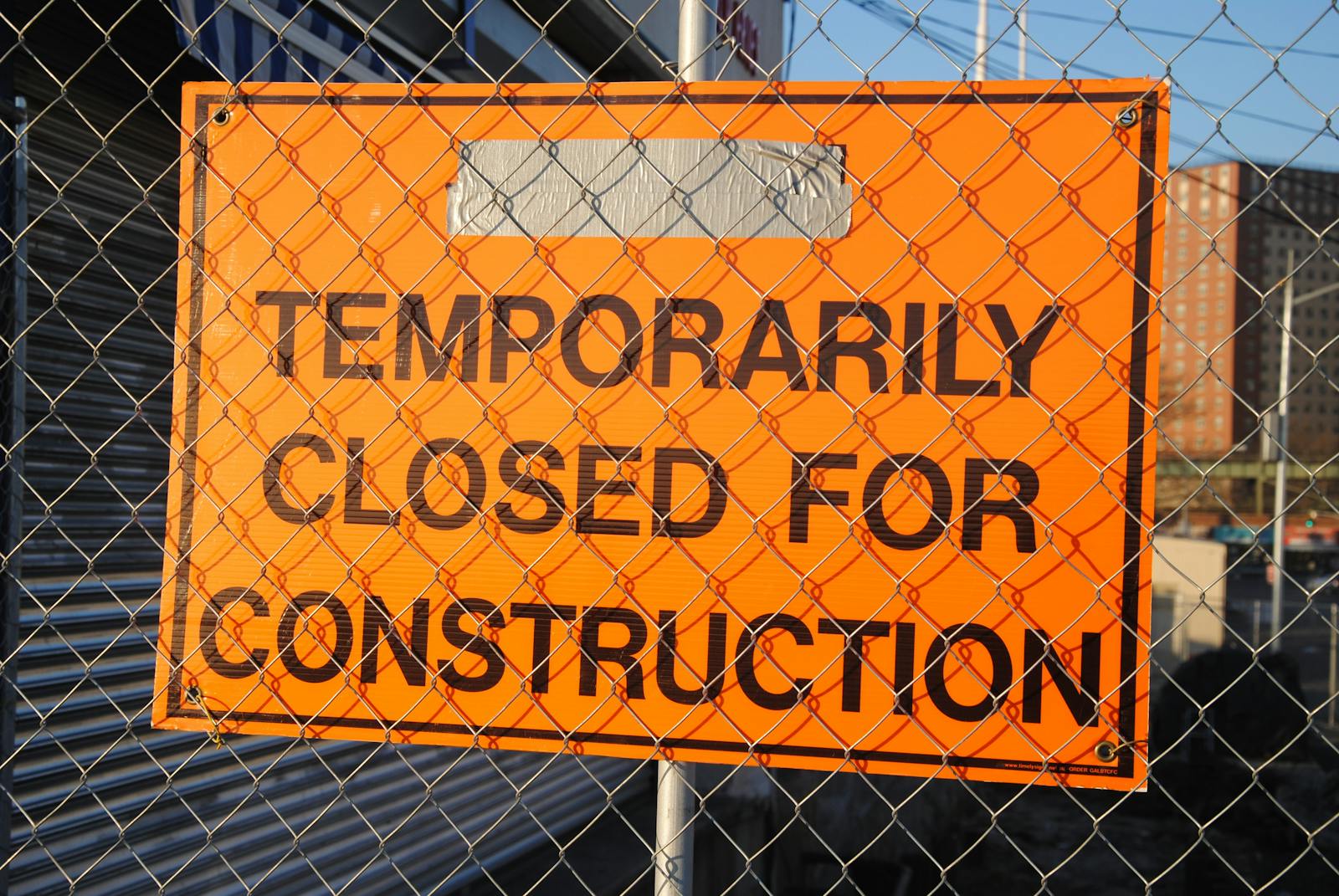 Photo by Pixabay Orange sign behind fence reading 'Temporarily Closed for Construction' at site.