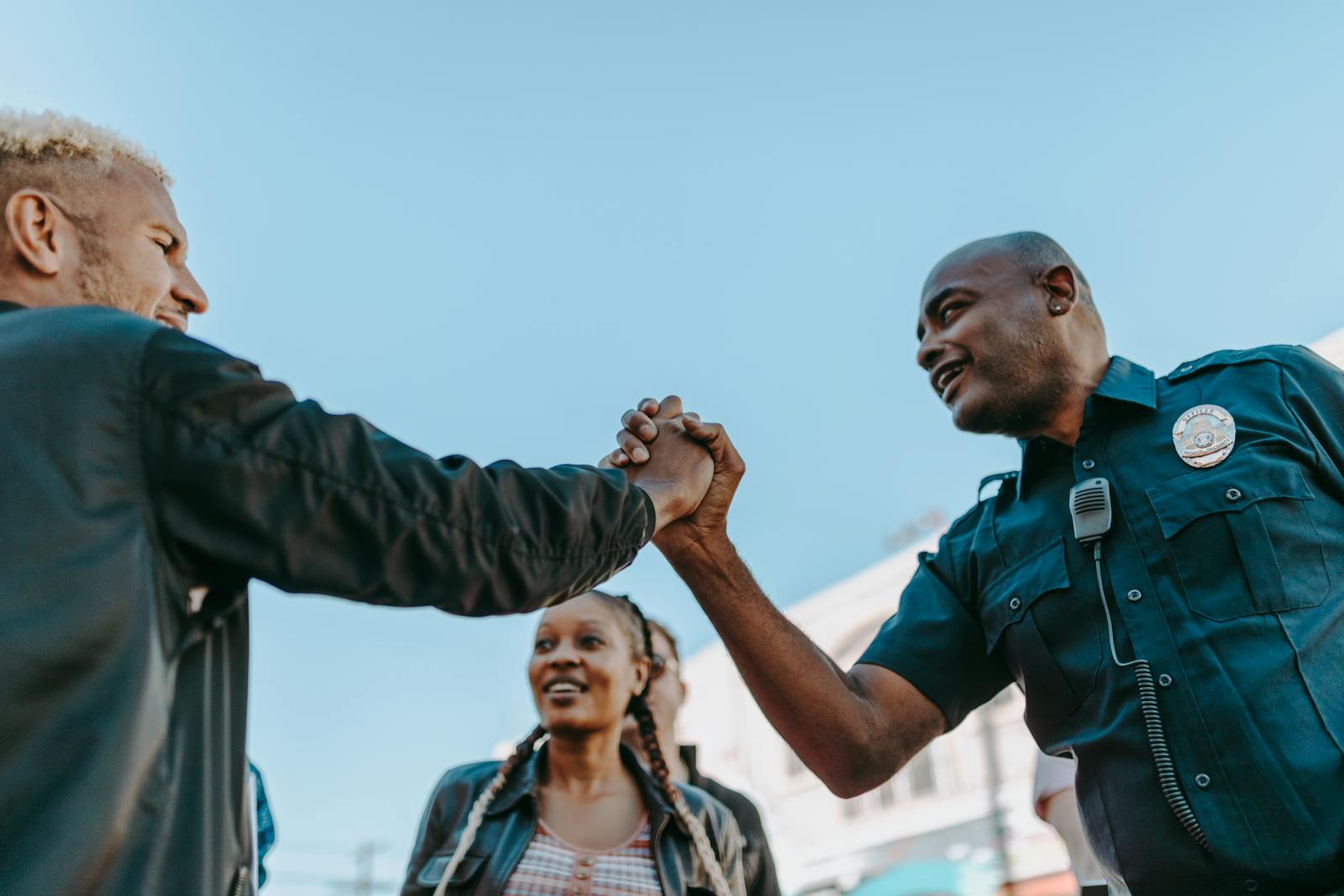 Photo by RDNE Stock project A friendly handshake between a police officer and a civilian during an outdoor community event.