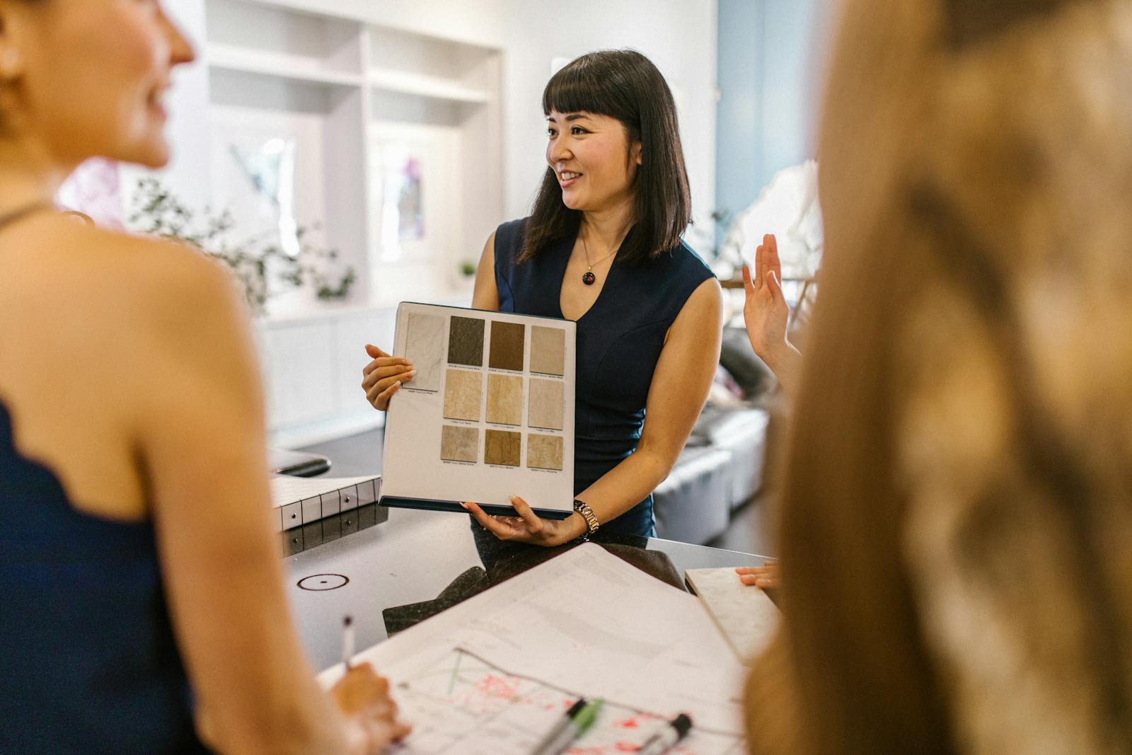 Photo by RDNE Stock project Interior designer presenting color swatches to clients in a modern workspace, fostering a creative atmosphere.